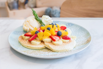Pancakes served with fruits and ice cream