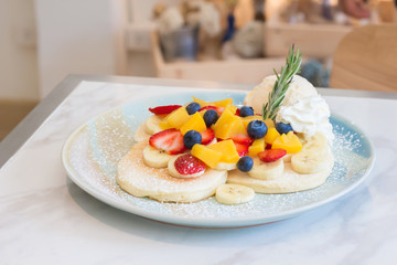 Pancakes served with fruits and ice cream