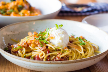 Poached egg on spaghetti with bacon and garlic