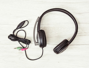 New headset with microphone on the wooden background