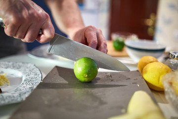Hands of man slicing limes