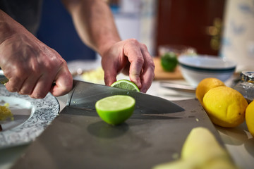 Hands of man slicing limes