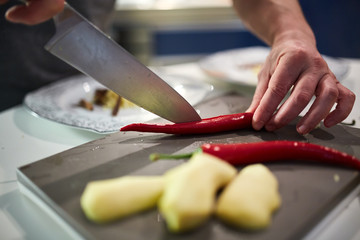 Hands chopping chili