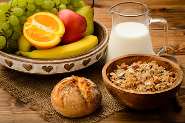 Healthy breakfast with muesli, milk, fresh fruits and nuts.