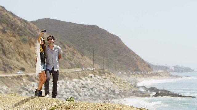 Couple taking a picture on the coast