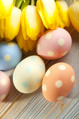 Tulip flowers and Easter eggs on wooden table