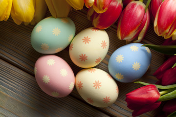 Fototapeta na wymiar Easter eggs and flowers on wooden background