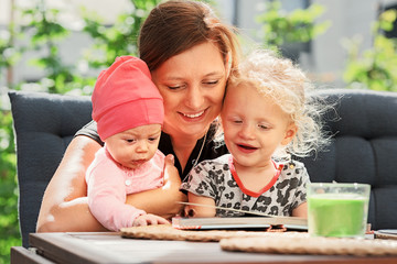 Mother and Daughters Looking at Children´s Book