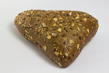 A bun in the form of a triangle sprinkled with sunflower seeds a