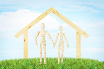 Joyous couple and a house outdoor. Abstract image with a wooden puppets