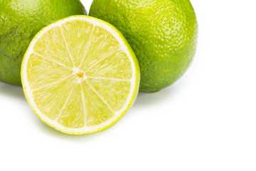 Group of fresh limes on white wooden surface