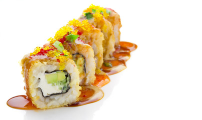 Crumch sushi roll with cheese and avocado decorated with green onion and spice sauces over white background