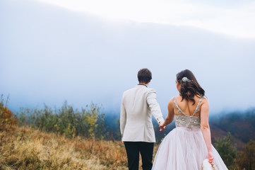 happy newly married couple posing in the mountains