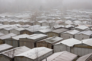 Snow-covered roofs of garages