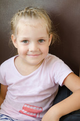 Naklejka premium Happy girl sitting on a chair in an electric train, close-up