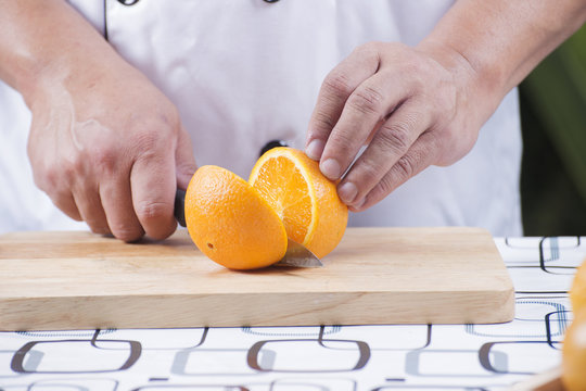 chef cutting orange