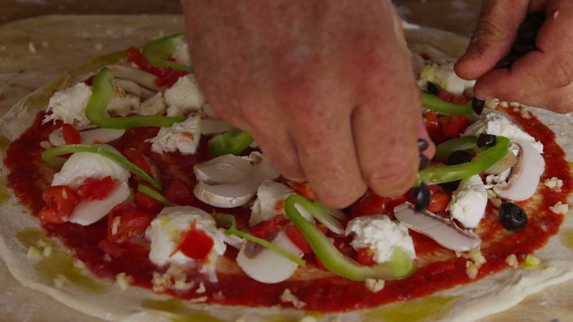Putting toppings on pizza