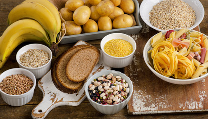 Foods high in carbohydrate on a rustic wooden table.
