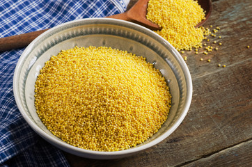 Organic millet in bowl on  wooden rustic table.
