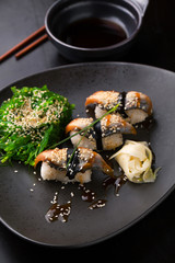 Sushi with smoked eel. Unagi nigiri and chuka salad with sauce a