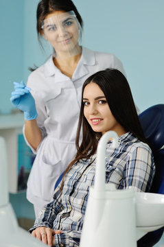 beautiful young girl on the background dentist with medical inst