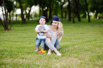 Mom and baby boy relaxing on green grass