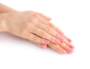 Closeup of hands of a young woman with pink manicure on nails against white background