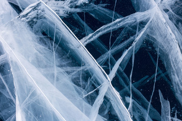 Network of cracks at icy surface of a frozen lake Baikal. Natural background