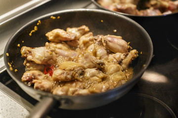 pan with chicken wings on the stove