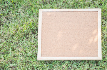 Fototapeta premium Closeup cork board on blurred grass floor texture background