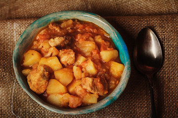 Roasted potatoes and meat in blue ceramic bowl