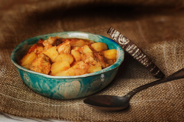 Roasted potatoes and meat in blue ceramic bowl