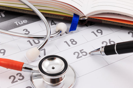Close up of stethoscope and pen on calendar, doctor appointment.