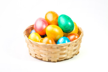 Easter eggs in a basket on a white background.