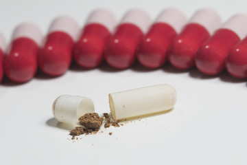 Row of red and pink probiotic and one broken