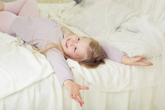 Child girl at early morning lying in bed