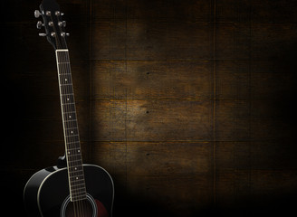 Fototapeta premium Black acoustic guitar on dark yellow wooden background.