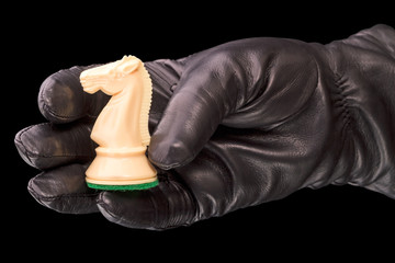 Black gloves and white chess knight © ra3rn
