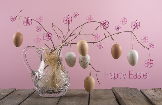 Happy Easter greeting card with eggs hanging on branch