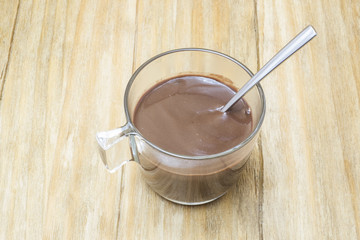 cup of hot cocoa with a spoon on a wooden table
