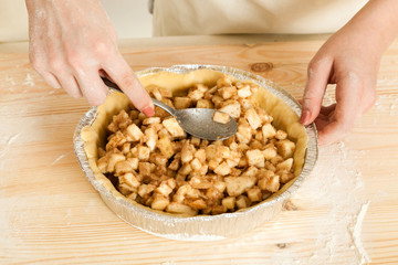 hand of the girl stack a stuffing in a form for pie