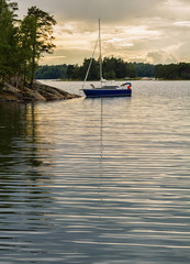 Sailboat anchored in the Baltic sea at sunset.
