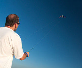 Man releasing a kite up in the air on sunny summer day