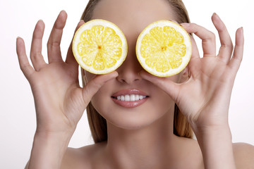 young happy woman showing a fresh lemon