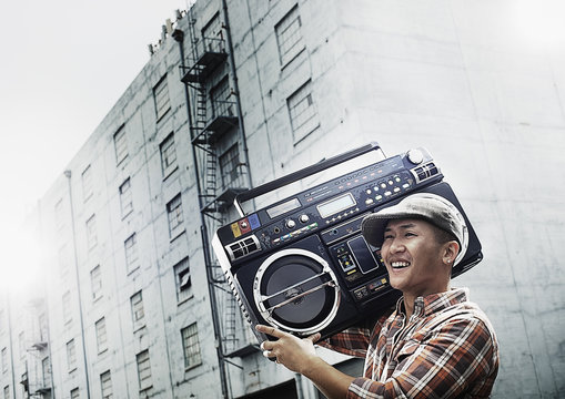 A young person with a boombox on the street of a city, 