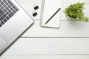 Office desk table with computer, supplies, flower. Top view. Copy space for text
