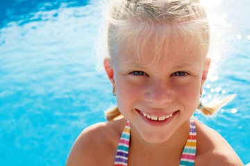 Fototapeta na wymiar Portrait of a little girl vacationers beside swimming pool in a