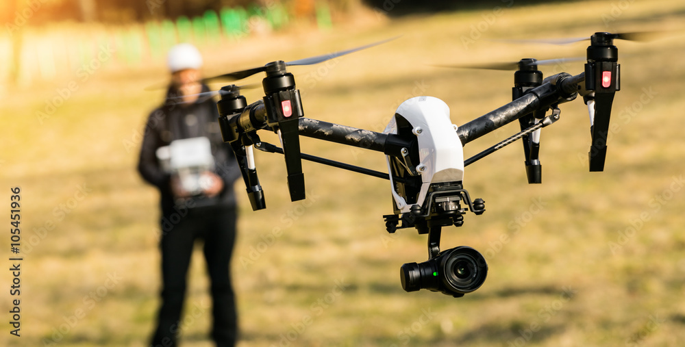 Wall mural man handling drone in nature