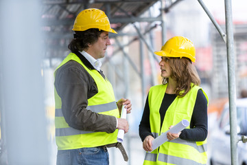 Male and female engineers talking on a construction site