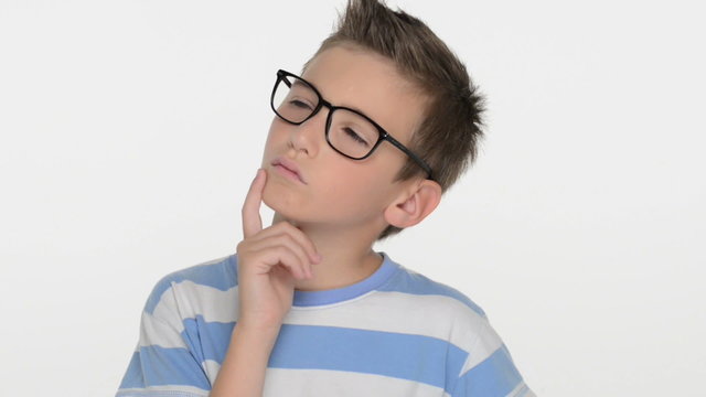 Serious  boy of ten years , wears glasses, looks at the camera and thinking